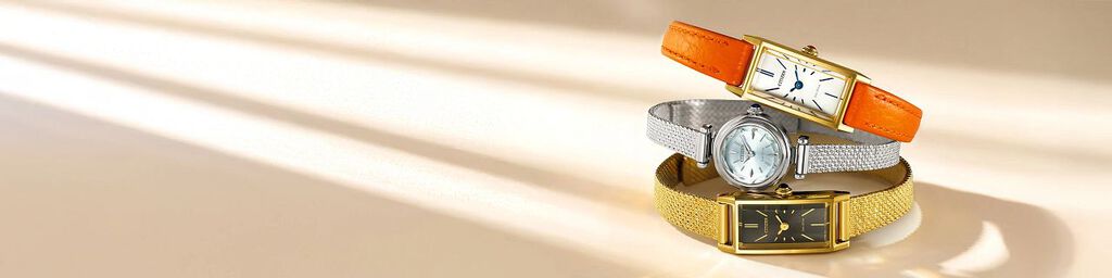 Women's Fio watches, three Fio watch models EG7081-51L, EG7122-04A and EG7128-59E stacked on top of each other on a yellow background