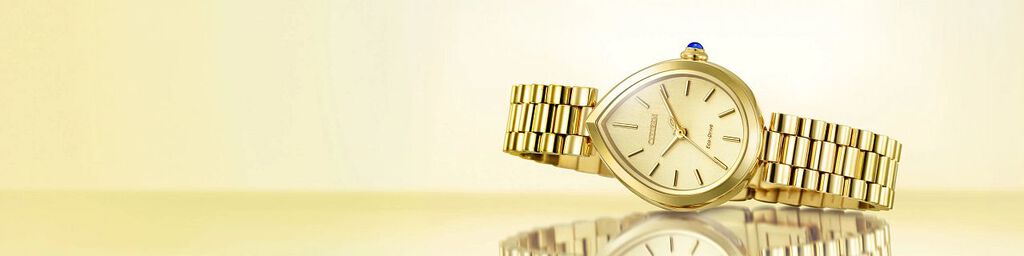 Women's Gold-Tone watches, featuring an image of Citizen L Rainell watch model EM1202-50P on a gold background