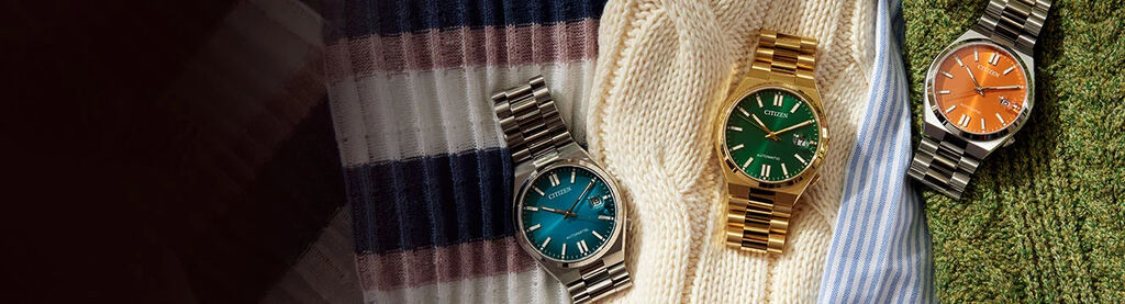 Image of three TSUYOSA models laying on top of sweaters. Image features watch models NJ0151-53X, NJ0152-51X and NJ0151-53Z