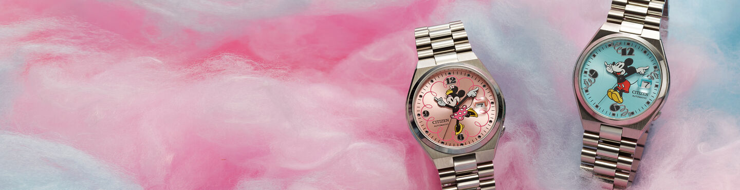 Men's Disney watches featuring TSUYOSA Minnie Mouse and TSUYOSA Mickey Mouse watch models NJ0150-50W and NJ0156-50L sitting on cotton candy background