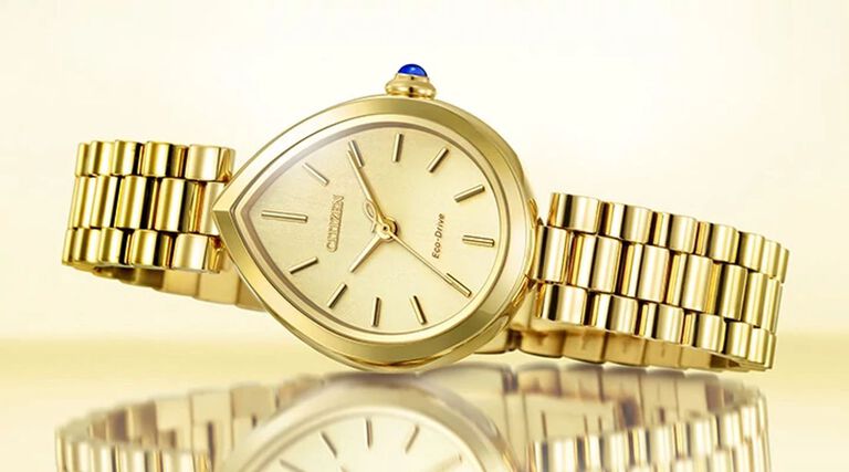 Women's Gold-Tone watches, featuring an image of Citizen L Rainell watch model EM1202-50P on a gold background