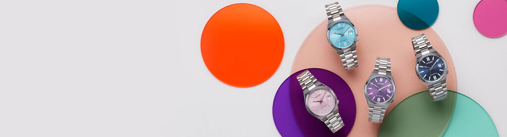 Image of four TSUYOSA 37mm models laying on top a colorful circles background. Image features watch models NJ0200-50L, NJ0200-50Z, NJ0200-50W and NJ0200-50M
